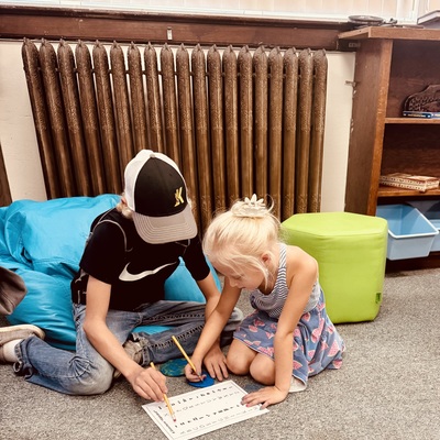 An older student teaching his younger sibling. We think this is so very important and so very good.